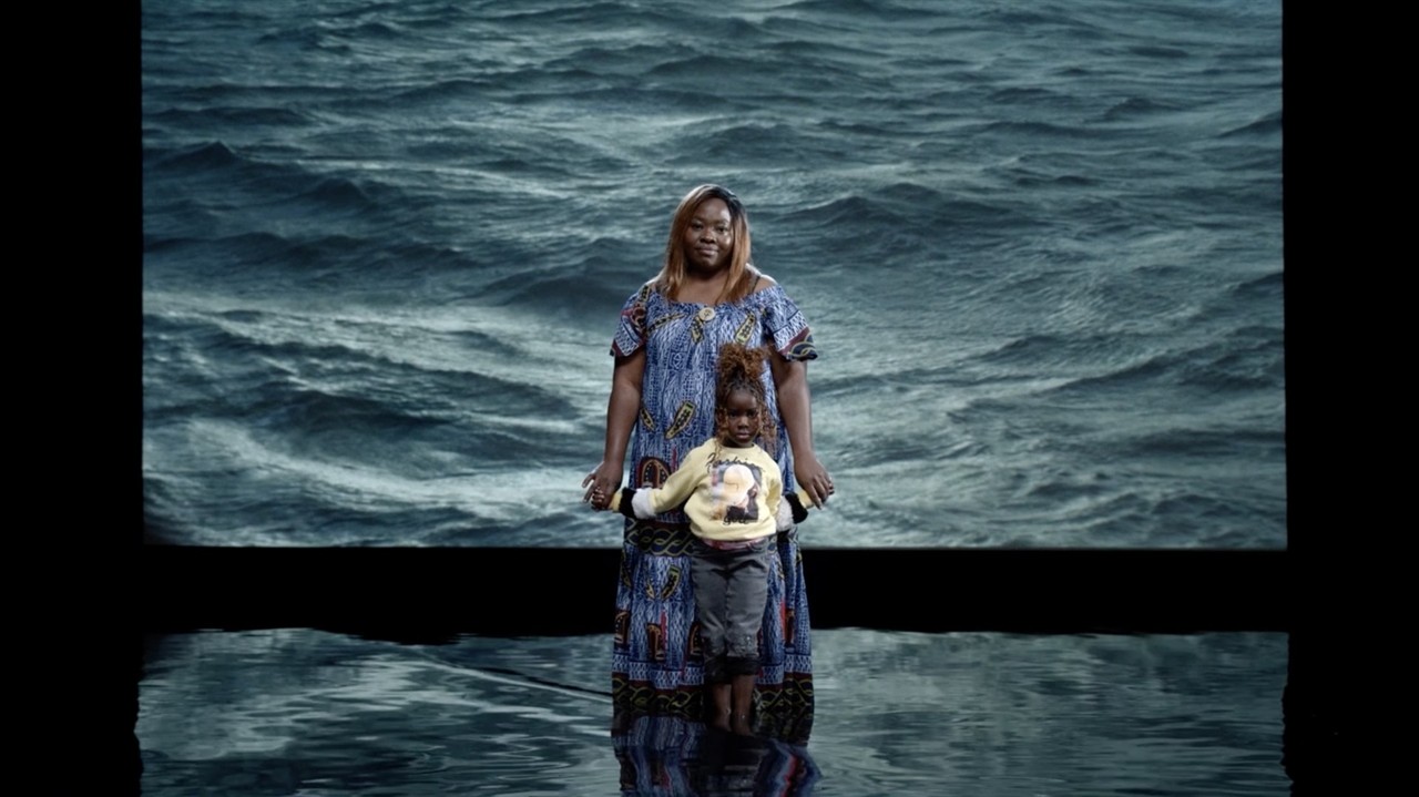 A woman and child in front of waves